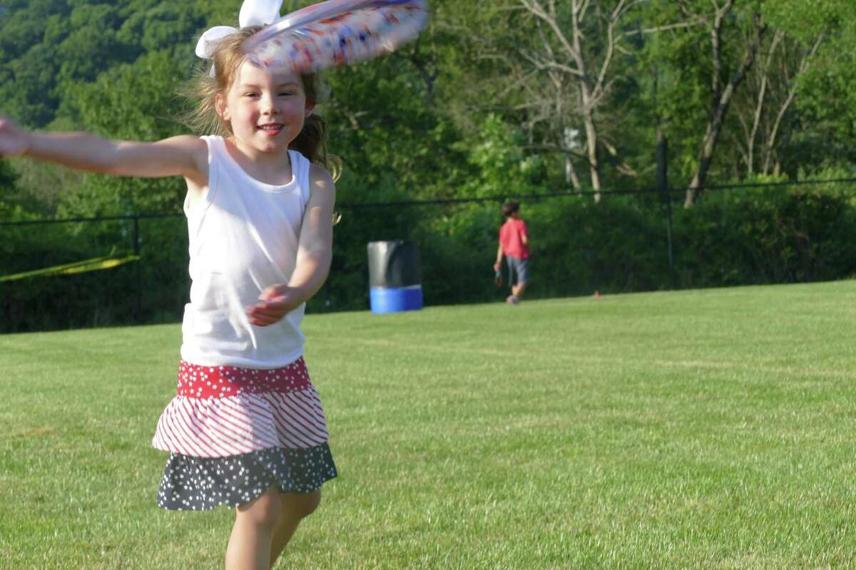 Maddie tosses a Frisbee during the town's annual Fourth of July celebration at Ridgefield High School last week.