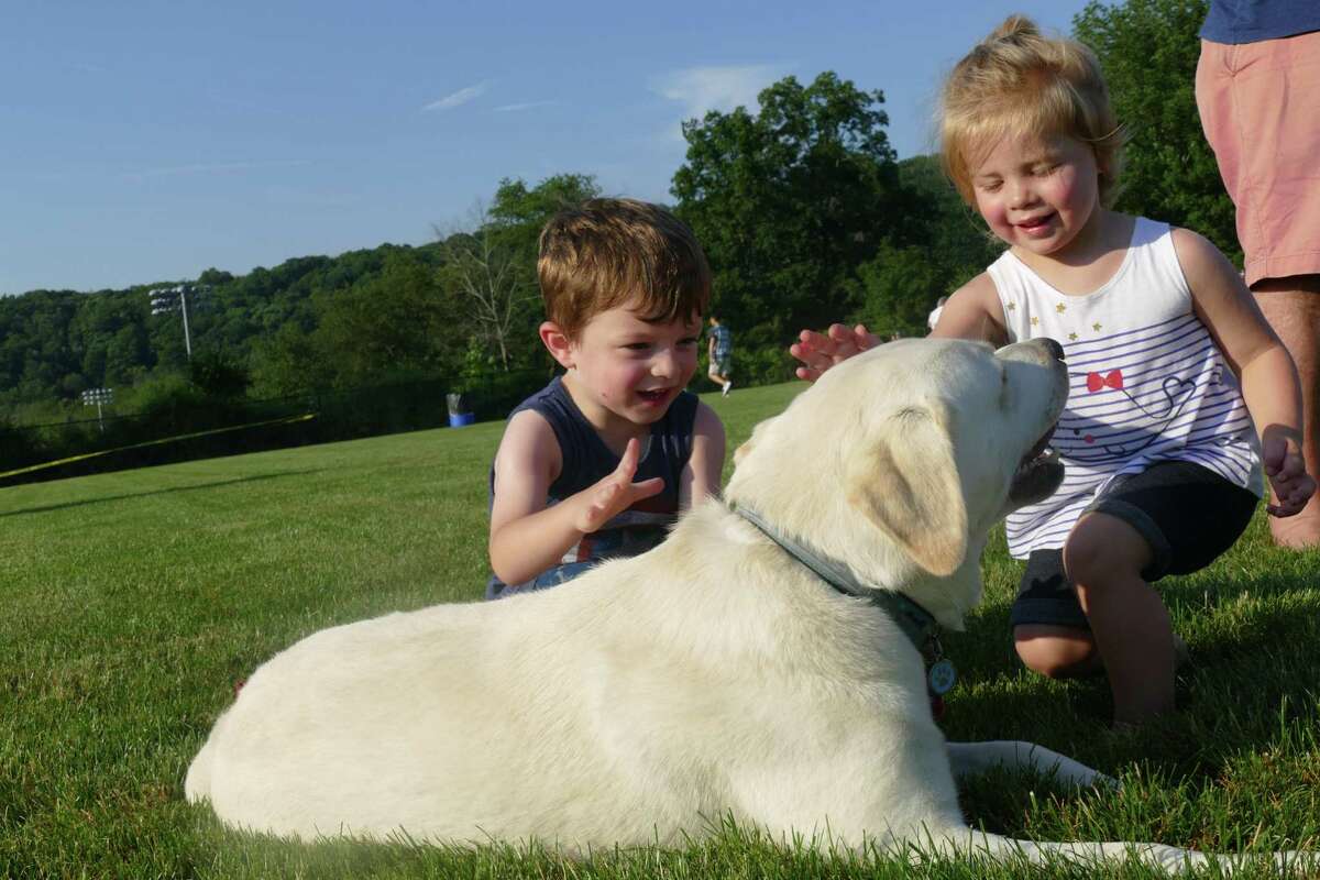 James and Kiera play with a new fury friend during the town's annual Fourth of July celebration at Ridgefield High School last week.