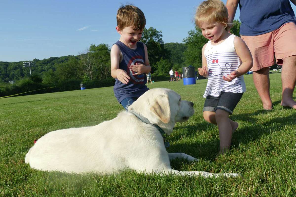 James and Kiera play with a new fury friend during the town's annual Fourth of July celebration at Ridgefield High School last week.