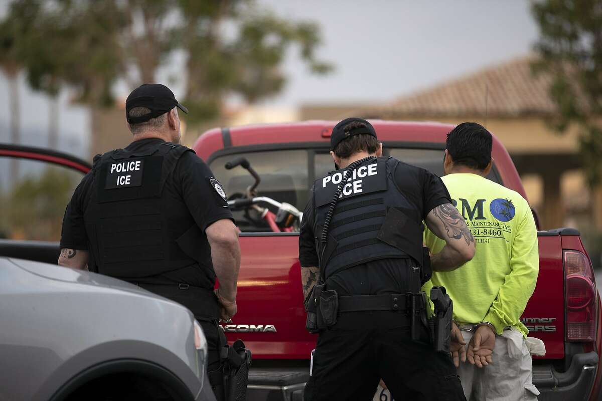 In this July 8, 2019, photo, a U.S. Immigration and Customs Enforcement (ICE) officers detain a man during an operation in Escondido, Calif. The carefully orchestrated arrest last week in this San Diego suburb illustrates how President Donald Trump's pledge to start deporting millions of people in the country illegally is virtually impossible with ICE's budget and its method of picking people up. (AP Photo/Gregory Bull)