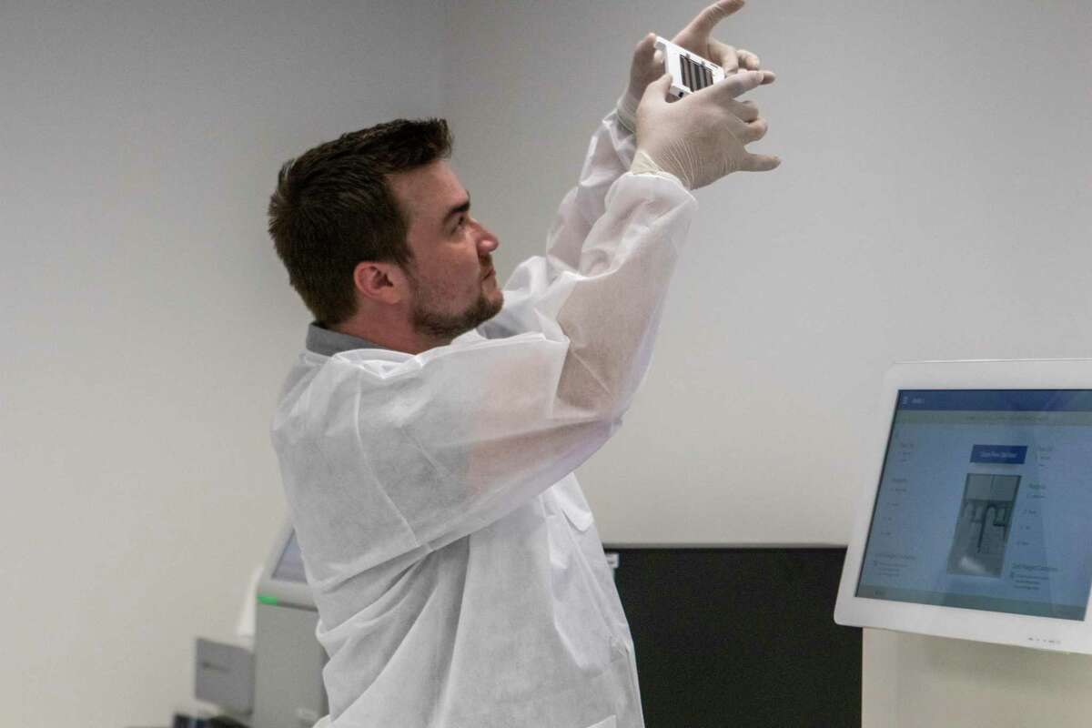 Lead next generation sequencing scientist Ian Wilson looks through a slide he is preparing to run through an Illumina NovaSeq 6000 sequencing system Friday, July 12, 2019 at the Othram lab in The Woodlands.