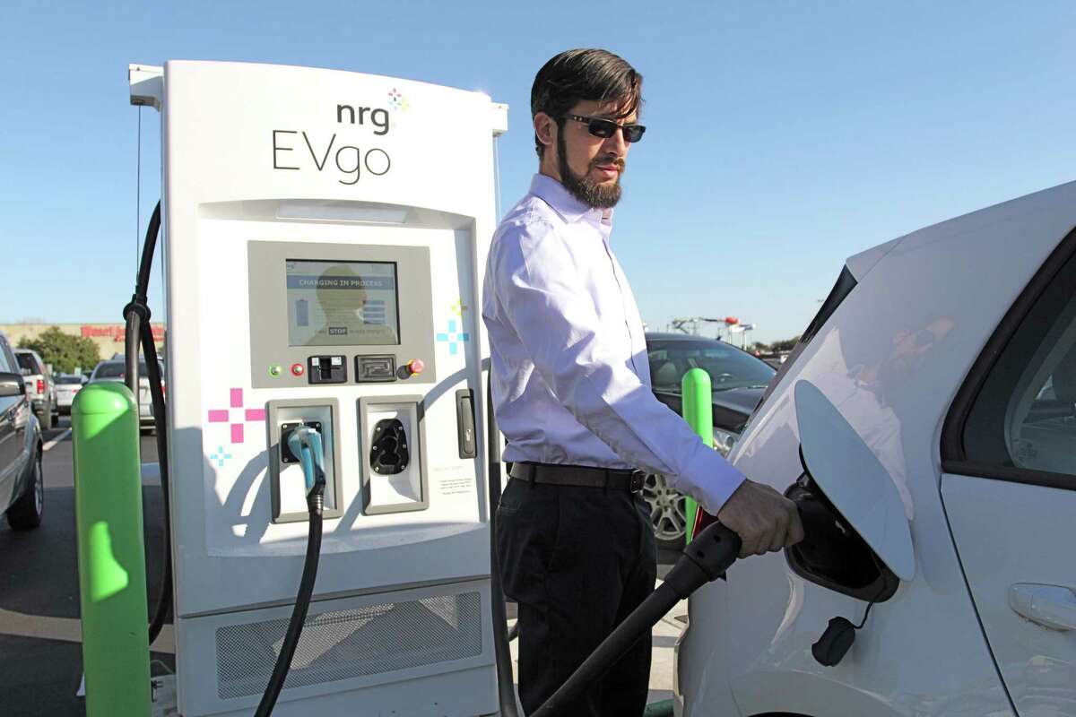 Anthony Martinez charges a VW e-Golf at an EVgo electric charging station in the Katy Mills Mall parking lot. Public charging stations help keep EV owners on the go.