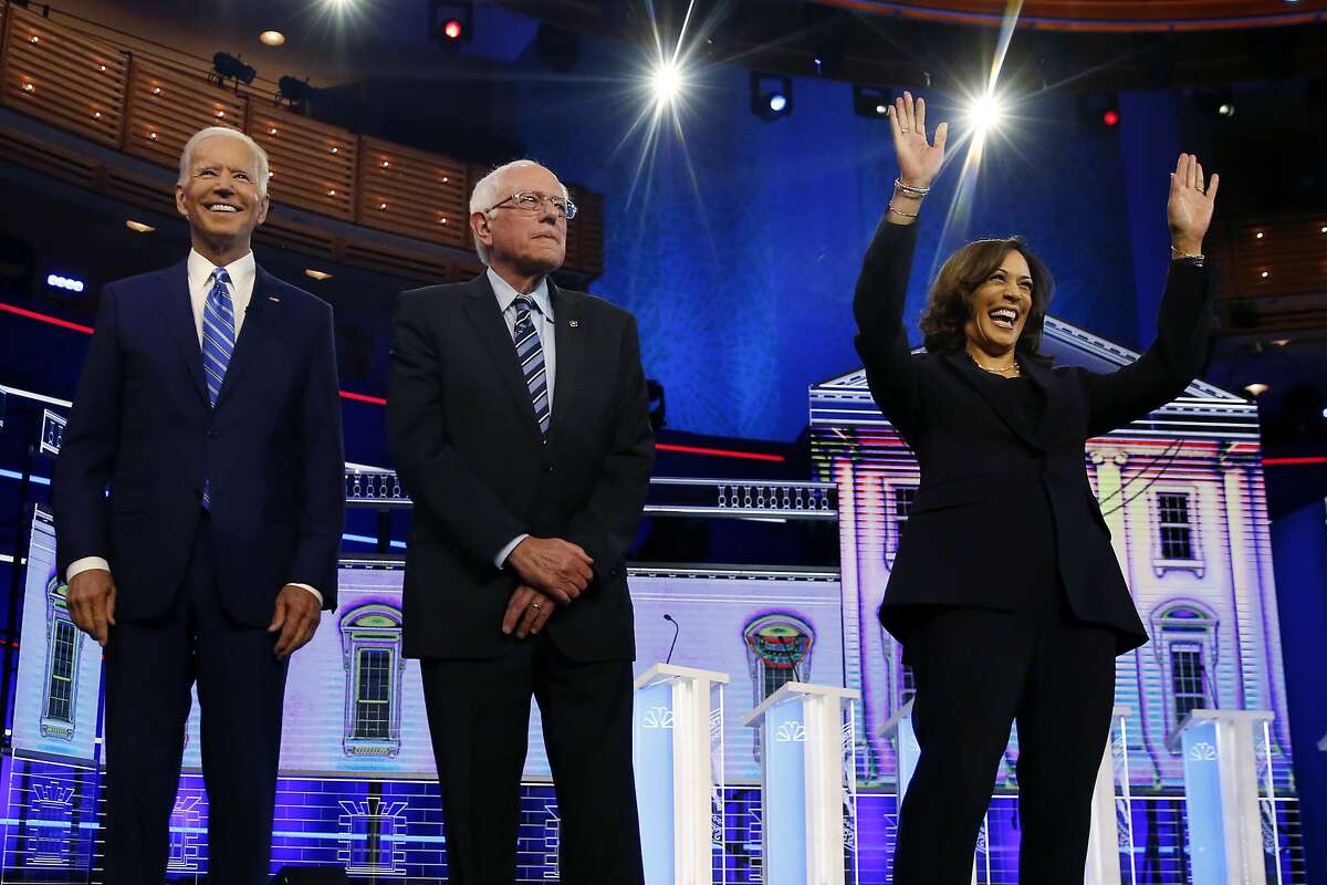 Democratic presidential candidates former vice president Joe Biden, left, Sen. Bernie Sanders, I-Vt., and Sen. Kamala Harris, D-Calif., right, stand on stage for a photo op before the start of the the Democratic primary debate hosted by NBC News at the Adrienne Arsht Center for the Performing Arts, Wednesday, June 27, 2019, in Miami. (AP Photo/Brynn Anderson)