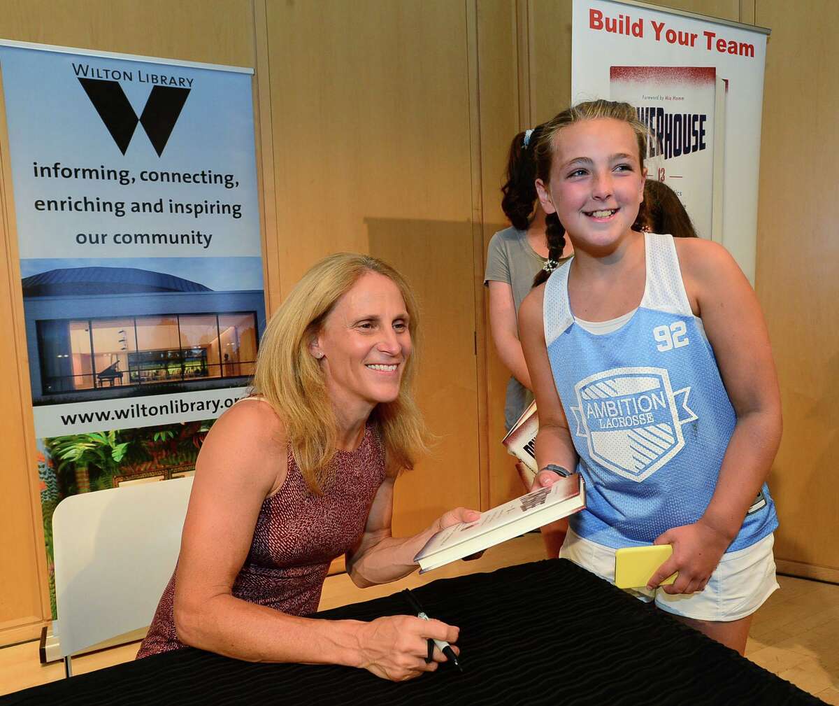 Wilton resident Annalise Lamanna, 12, gets a book signed by Wilton High School graduate and soccer star Kristine Lilly.