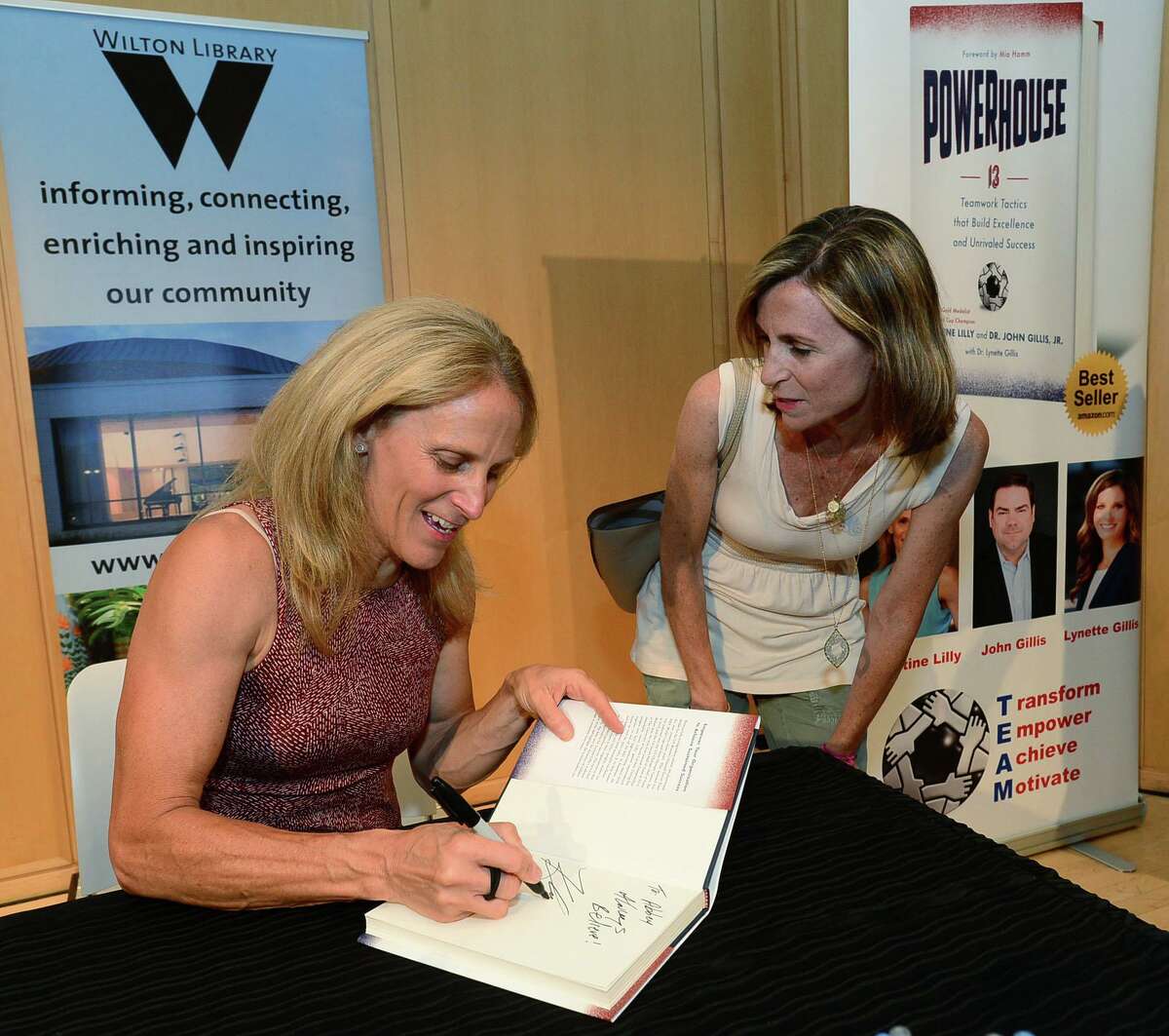 Wilton resident Kerry Byrnes gets her book signed after Wilton High School graduate and soccer star Kristine Lilly spokeTuesday, July 16, 2019, at Wilton Library in promotion of her new book, PowerHouse, in Wilton, Conn.