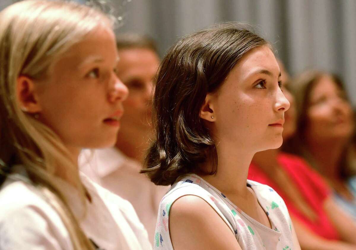 Audience members listen as Wilton High School graduate and soccer star Kristine Lilly speaks Tuesday, July 16, 2019, at Wilton Library in promotion of her new book, PowerHouse, in Wilton, Conn.