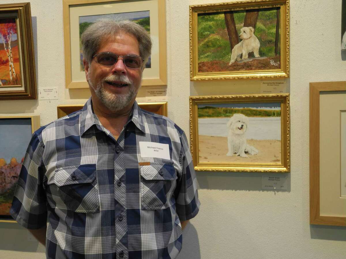 Michael Franco with portraits of two of the dogs he and his wife Mary Anne have owned that he entered in the Summer Show at Wilton Library. Wilton, Conn., July 12, 2019.