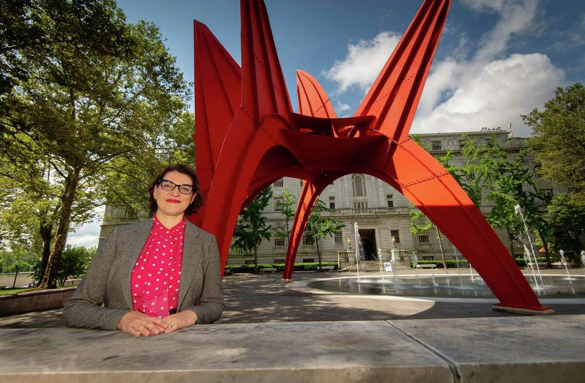Mary Donegan, an urban planner and teacher at the University of Connecticut in Storrs, stands near Alexander Calder's Stegosaurus sculpture in Hartford's Burr Mall on Friday, July 12, 2019.