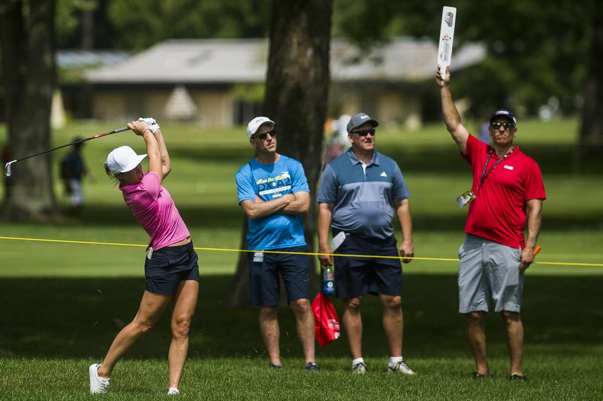 A volunteer holds up a "Quiet" sign as Mel Reid of England competes in the Dow Great Lakes Bay Invitational on Wednesday, July 17, 2019 at Midland Country Club. (Katy Kildee/kkildee@mdn.net)