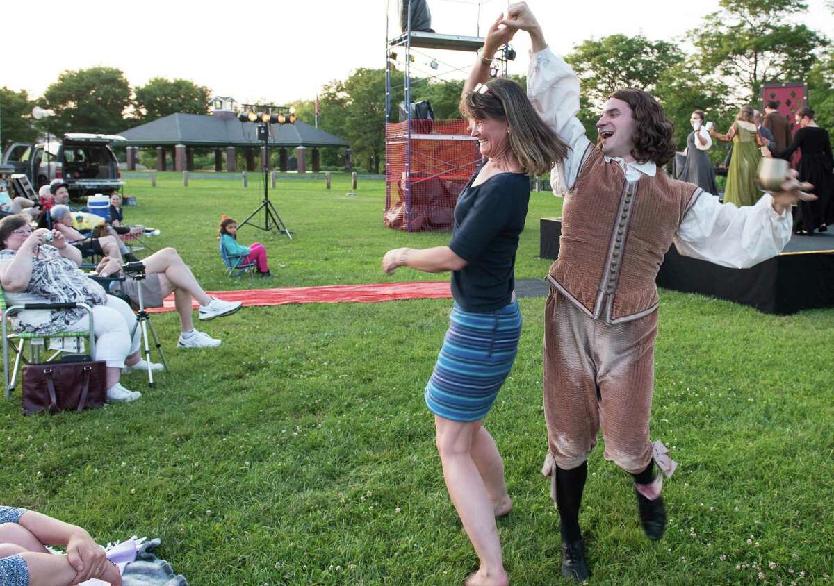 Matthew (Lord Chamberlain) dances with a member of the audience at the Valley Shakespeare Festival production of King Henry VIII at the Veterans Memorial Park on Sunday.