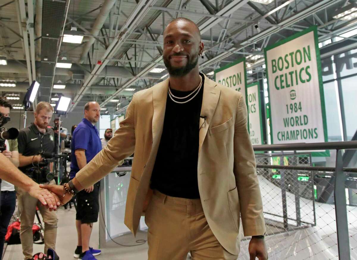 Newly acquired Celtics guard Kemba Walker shakes a hand as he leaves an interview at the Celtics’ basketball practice facility on Wednesday.