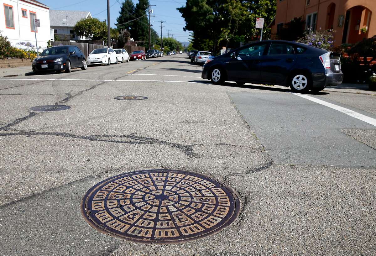 A motorist drives past a manhole cover at Stuart Street and McGee Avenue in Berkeley, Calif. on Wednesday, July 17, 2019. The Berkeley City Council passed an ordinance to replace gendered language in the city’s municipal code with neutral terms, so these would no longer be referred to as "manhole" covers.