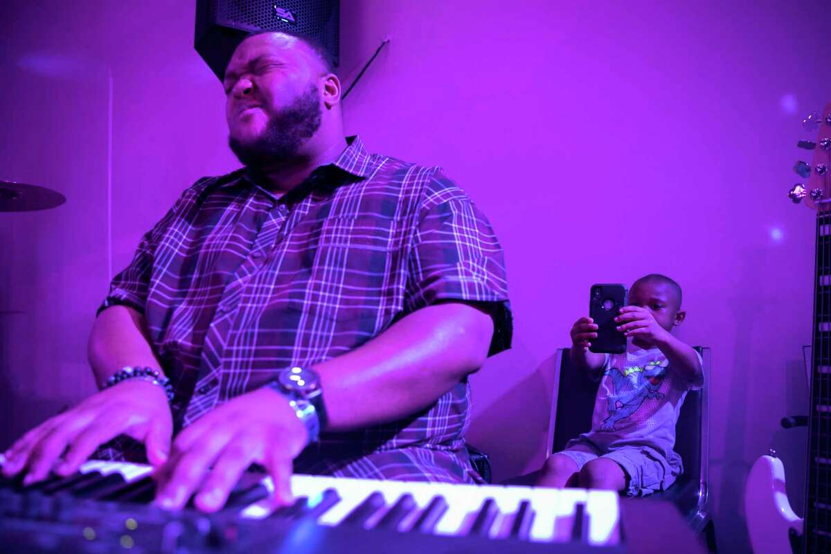 Zach Fisher plays the keyboard while his six-year-old son Cameron films him during the second Shift Christian Lounge event on Saturday, July 5, 2019, at God Encounter Church in northwest Houston.