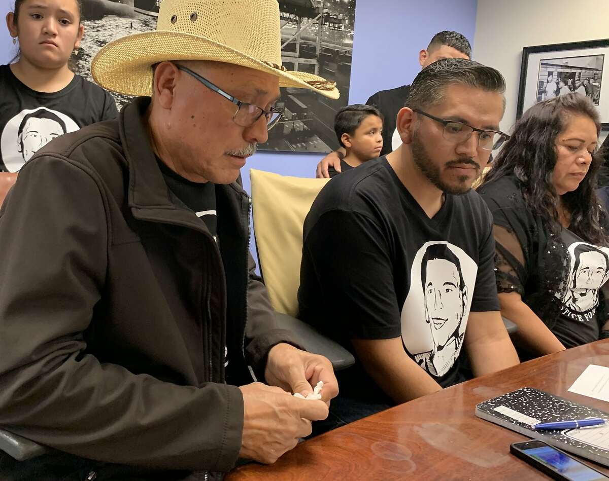The City of Newark settled a federal civil rights lawsuit with the family of a man shot and killed by a police officer after robbing a KFC with a replica gun. Teodoro Valencia (left), father of Teodoro Valencia Jr., reacts to the settlement at a Thursday press conference in Oakland .