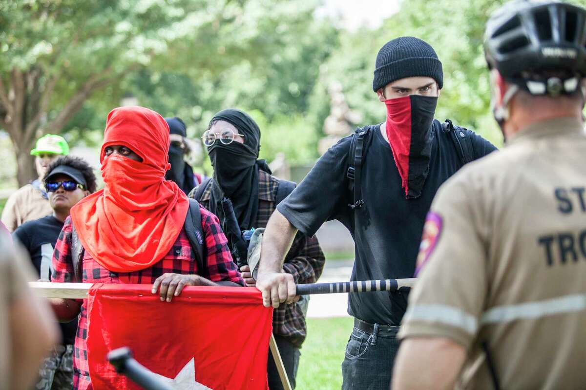 Protesters who identified themselves as Antifa International members stare down state troopers during a counter white supremacy march to the Capitol in Austin on September 23, 2017.