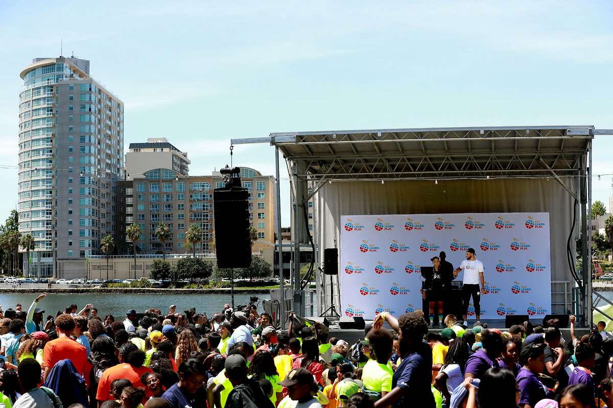 Ayesha Curry stands on stage with her husband, Golden State Warriors guard Stephen Curry, during the launch of Eat, Play, Learn, at Lakeside Park at Lake Merritt in Oakland, Calif., on Thursday, July 18, 2019. The couple started the new foundation that focuses on providing support for the 3 basic ingredients of a healthy childhood. They are partnering with Oakland Parks and Recs and other local entities to provide services for underserved Oakland children.