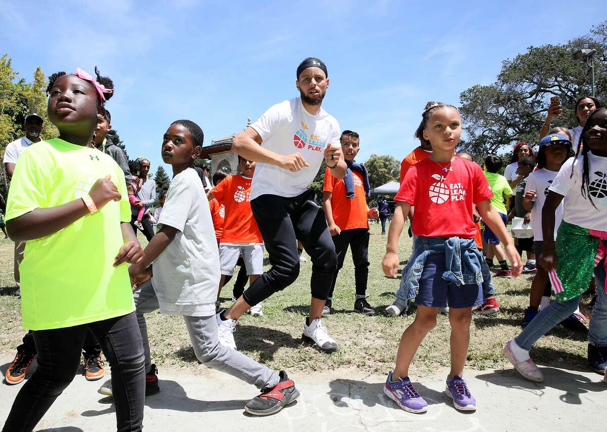 Golden State Warriors guard Stephen Curry dances with his daughter Riley (second from right in red t-shirt), who turns 7 this week, during the launch of Eat, Play, Learn, at Lakeside Park at Lake Merritt in Oakland, Calif., on Thursday, July 18, 2019. Curry and his wife Ayesha started the new foundation that focuses on providing support for the 3 basic ingredients of a healthy childhood. They are partnering with Oakland Parks and Recs and other local entities to provide services for underserved Oakland children.