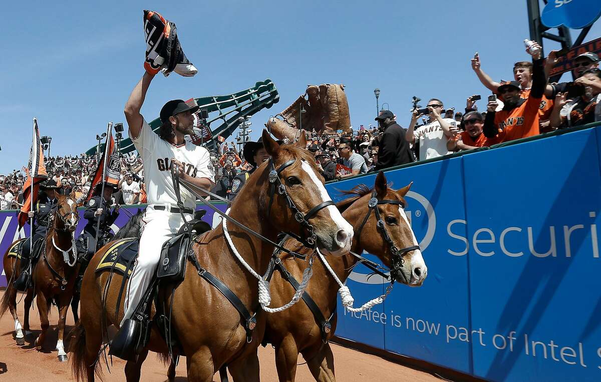 San Francisco Giants pitcher Madison Bumgarner carries the 2014 Giants championship pennant while riding a San Francisco Police horse in the AT&T Park outfield before a baseball game between the Giants and the Colorado Rockies in San Francisco, Monday, April 13, 2015. (AP Photo/Jeff Chiu, Pool)