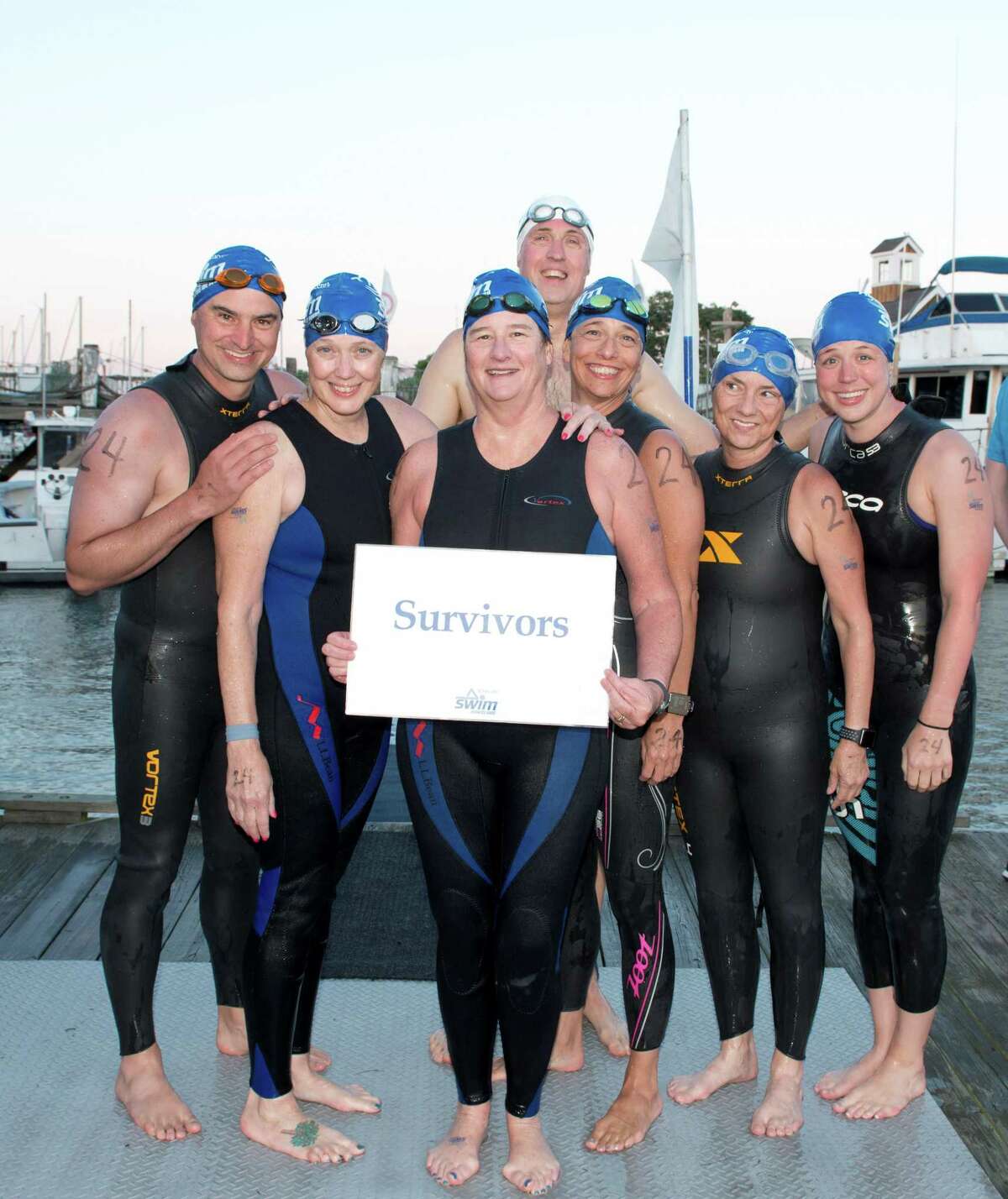 Teresa Gagnon, center, holding the sign at the SWIM Across the Sound Marathon in 2017.