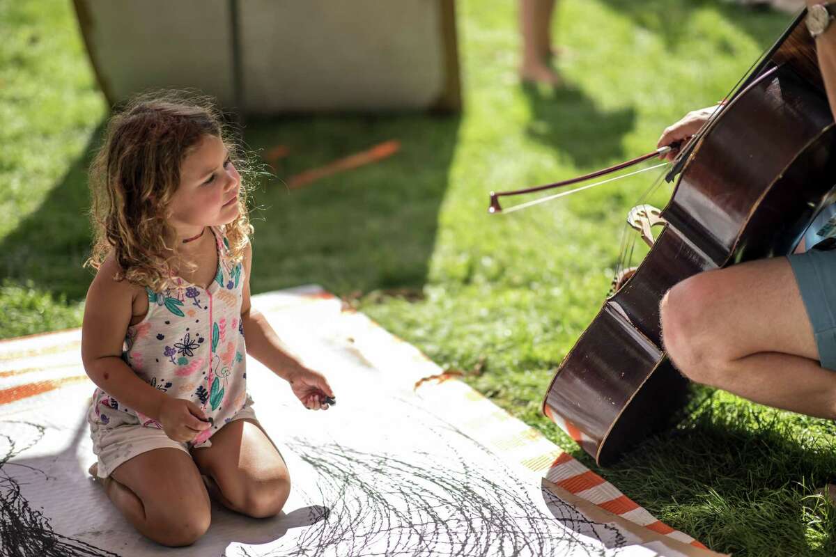 A child gets a closeup view of a cello at last year’s Five Senses Festival.