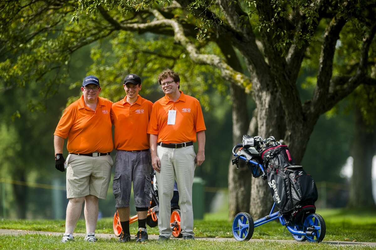 From left, Nick McCabe, Justin Doran and Nick Wagenmaker pose for a photo while competing in the Special Olympics 3-Hole Challenge on Friday, July 19, 2019 at Midland Country Club. (Katy Kildee/kkildee@mdn.net)