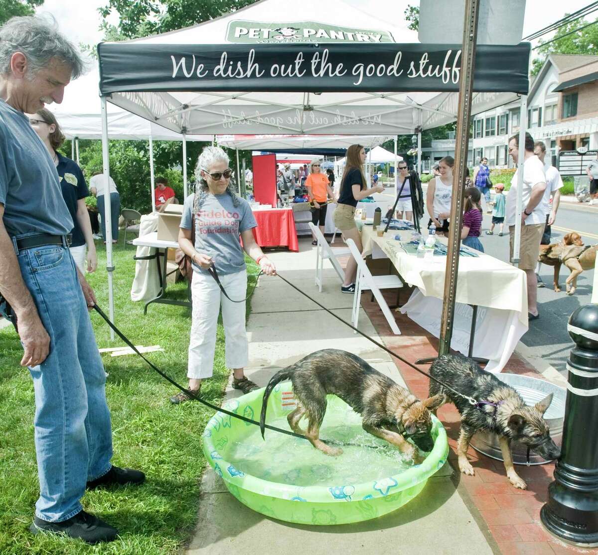 A couple of happy dogs found a way to beat the heat at last year's Street Fair and Sidewalk Sale in Wilton.