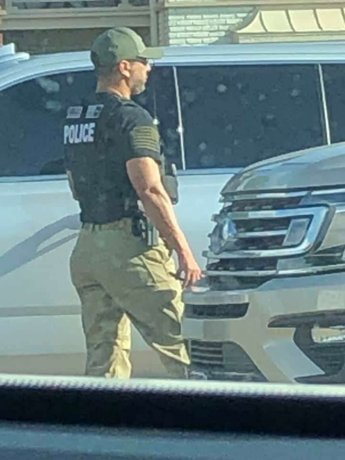 An immigration officer stands at a scene in southwest Houston where a man was injured in a crash involving a pursuit by immigration authorities.