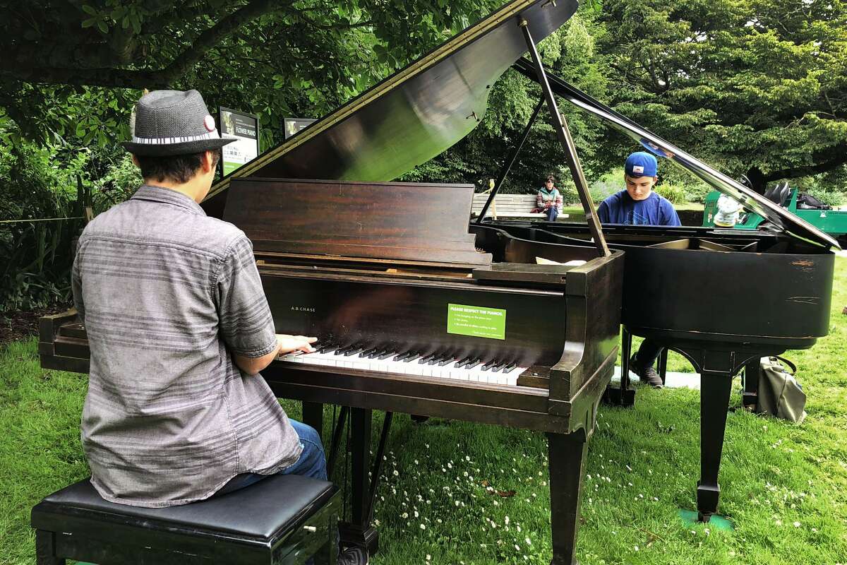 Gavin Bermudez, left, and Oscar Cervarich play the piano at Flower Piano at the San Francisco Botanical Garden.