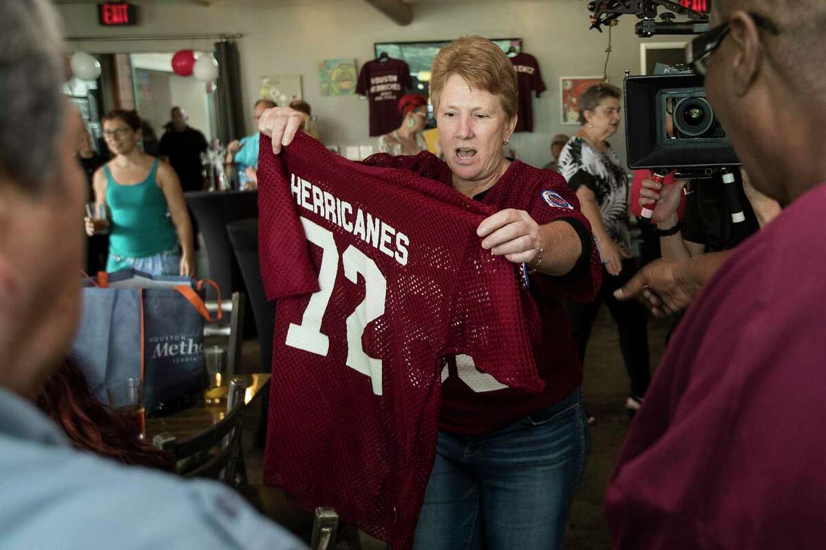 Billie Cooper lifts up a Houston Herricanes jersey during a reunion of Herricanes, the city's first professional women's football team, on Saturday, July 13, 2019, in Houston. The reunion marked the first time in 40 years the women who played in the NWFL gathered to relive the memories of their playing days.