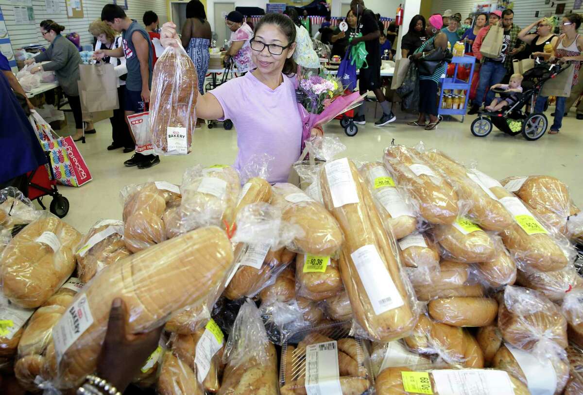Carmen Figueroa picks out a loaf of bread at the Blessed Angels food distribution in July 2019. The food pantry is one of the services listed on the San Antonio Community Resource Directory website.