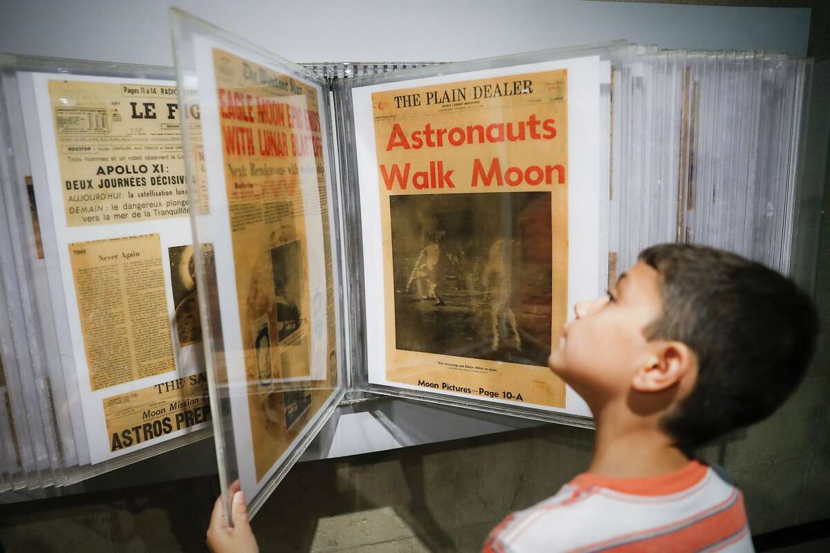 Ethan Reynolds browses a display of archival newspaper front pages announcing the first moon landing at the Armstrong Air & Space Museum as special events are underway for visitors commemorating the milestone's 50th anniversary, Saturday, July 20, 2019, in Wapakoneta, Ohio. (AP Photo/John Minchillo)