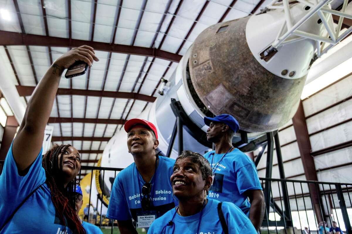 Fallon Vallair, of Houston, Ann Minkins, and Judith Johnson both of Beaumont, take a photo in front of the Saturn V rocket on display at Rocket Park during the 50th anniversary celebration of the Apollo 11 moon landing at Space Center Houston on Saturday, July 20, 2019, in Houston.
