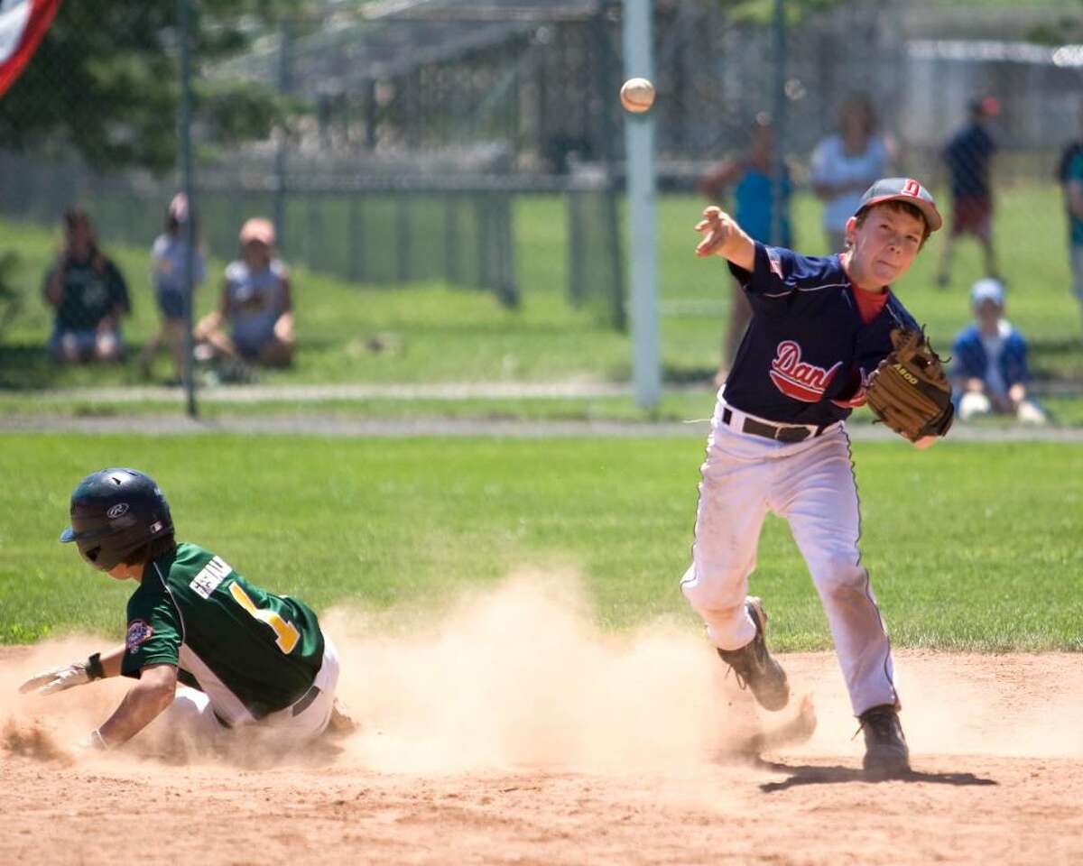 Danbury shortstop Eric Cerno turns a double play in the Cal Ripken 11-year-old state tournament championship game Saturday at Rogers Park. The play started with a hot shot at second baseman Brent Jacobellis. New Milford won, 10-6.