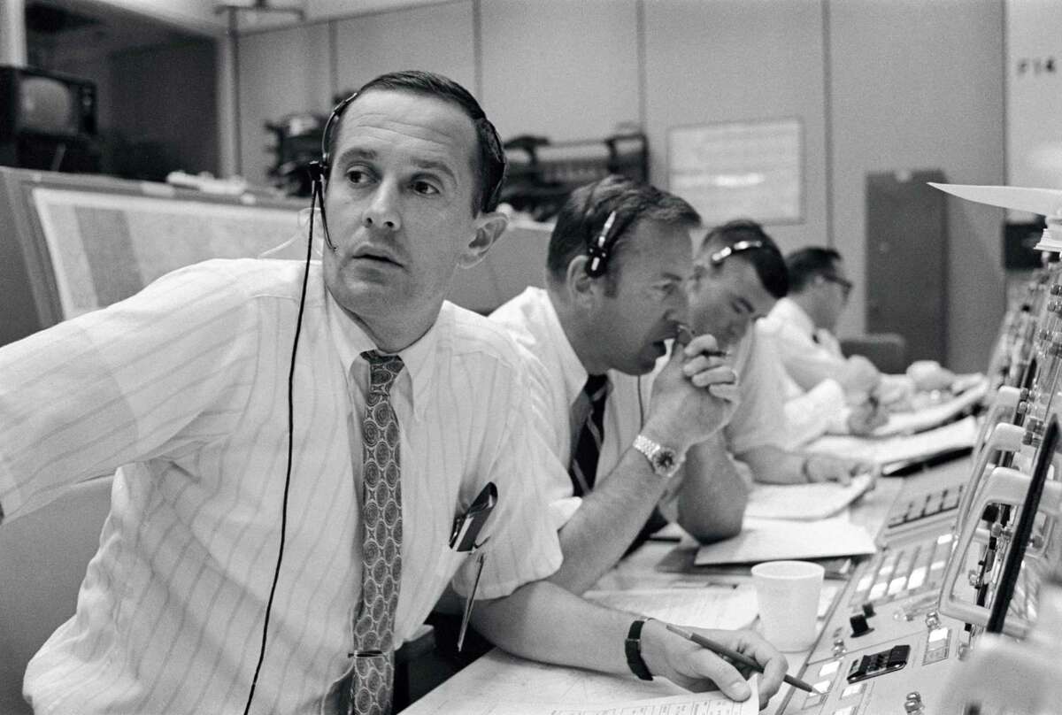 Flight controllers keep in contact with the Apollo 11 astronauts during their lunar landing mission on July 20, 1969. From left to right are astronauts Charles M. Duke Jr., James A. Lovell Jr. and Fred W. Haise Jr.