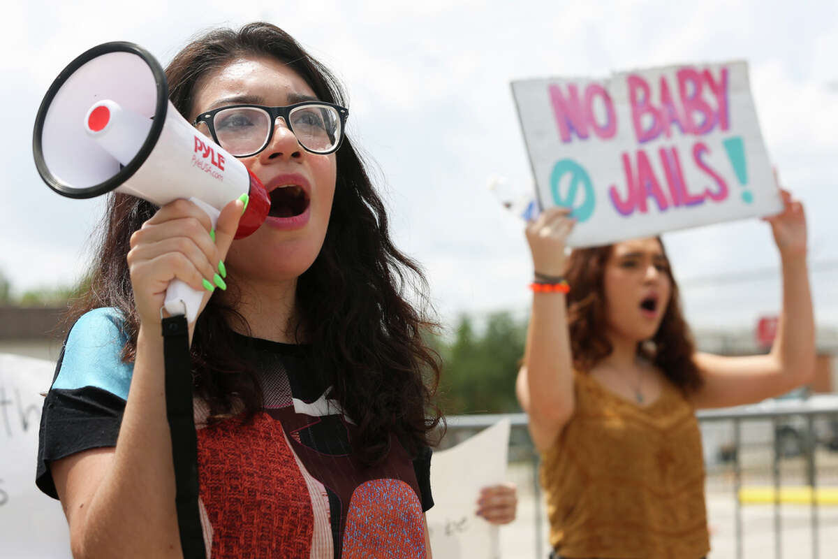 Norma González, left, and Akira Clark protest against the Southwest Key Detention Center on Emancipation Ave in Houston, Sunday, July 21, 2019. Never Again Is Now-Houston organized the protest against ICE and the detention center.