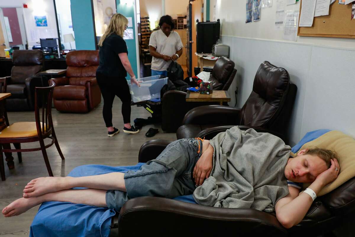 Lindsey Cassidy (bottom) sleeps as Breanna Blueford (top,right) gets her belongings together at the Dore Urgent Care clinic which is a crisis drop-in center for mental health needs in San Francisco, California, on Monday, June 10, 2019. Supervisors Matt Haney and Hillary Ronen have proposed a sweeping ballot measure to overhaul the city's mental health care system.