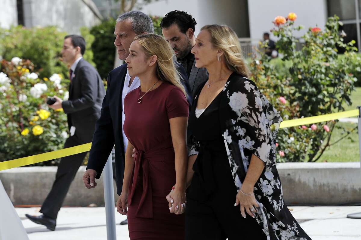 Carli Skaggs, center in burgundy dress, walks into St. Monica Catholic Church for a memorial for her husband, Los Angeles Angels pitcher Tyler Skaggs, Monday, July 22, 2019, in Los Angeles. (AP Photo/Marcio Jose Sanchez)