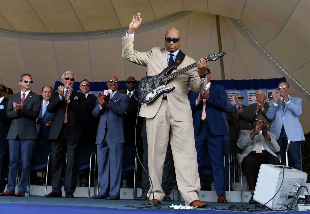 Former New York Yankees player Bernie Williams, foreground, performs during a National Baseball Hall of Fame induction ceremony at the Clark Sports Center, Sunday, July 21, 2019, in Cooperstown, N.Y. (AP Photo/Hans Pennink)