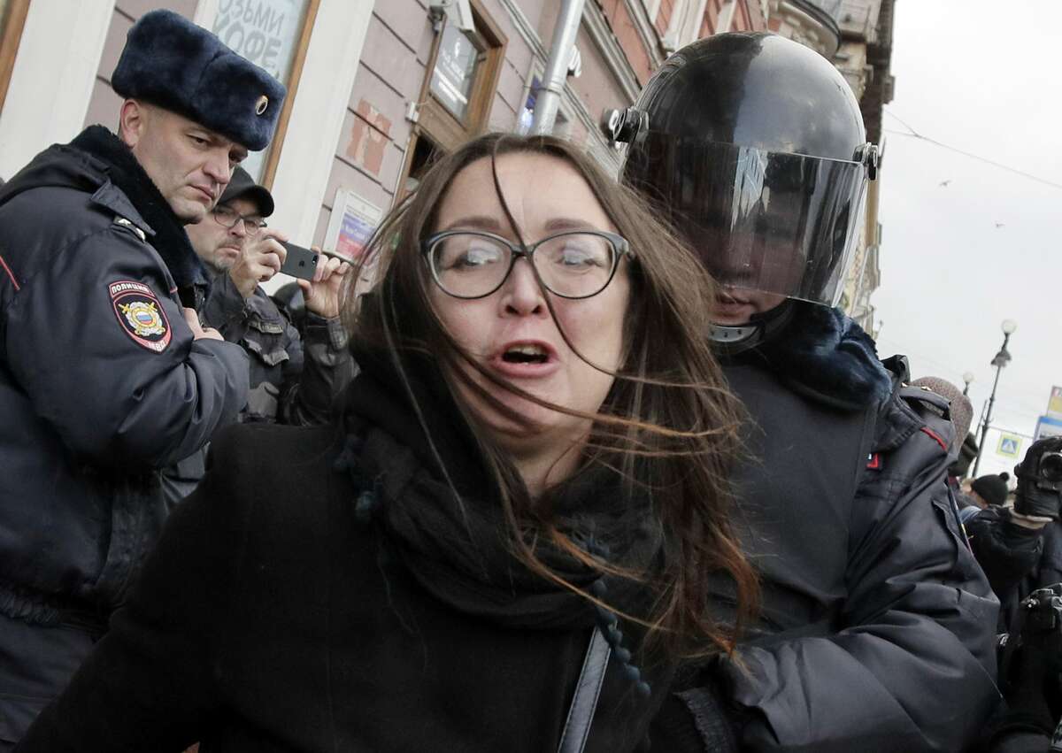 FILE - In this Sunday, Oct. 28, 2018 file photo, a policeman detains political and LGBT rights activist Yelena Grigorieva during a rally in support of the defendants involved in the Novoye Velichye (New Greatness) case in St. Petersburg, Russia. Yelena Grigorieva was killed over the weekend. Her body was found Saturday July 20, 2019, near her home with eight stab wounds and signs of strangling. (AP Photo/Dmitri Lovetsky, File)
