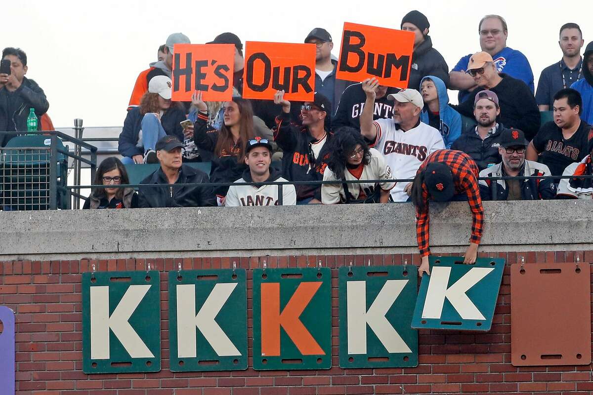 Wearing a Madison Bumgarner jersey, Adam Serrano and his son Christian, 5  1/2, settle into their seats for the Giants game against the Chicago Cubs  at Oracle Park in San Francisco, Calif.