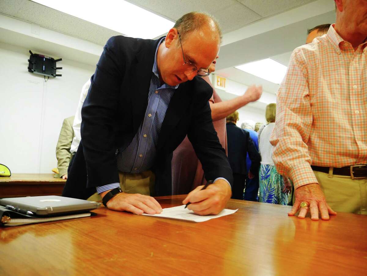 Republican nominee for the Ridgefield Board of Education Sean McEvoy signs his endorsement sheet Tuesday, July 23