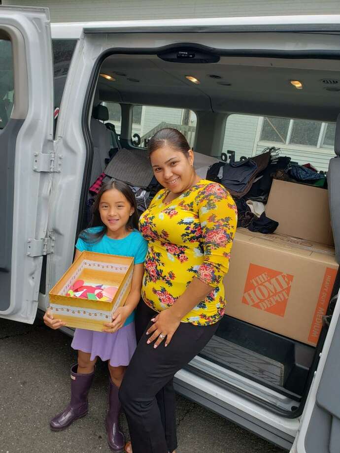 Ridgefield Girl Scout Ruby Weiner presents donations to Grixaliz Montes of Dress for Success at the scouts end-of-year donation drive event on July 23. Ridgefield Girl Scouts filled a van with clothing, wrote "Notes of Encouragement," and held the biggest donation drive to date for Dress for Success. Photo: Patty Labozzo / Contributed