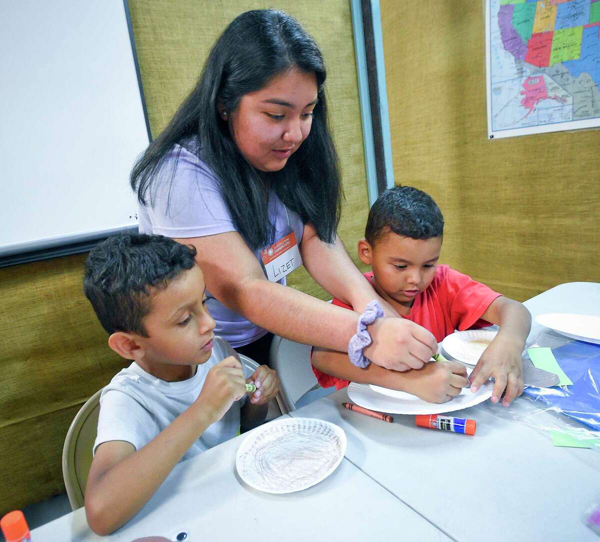 Volunteer Lizet Garcia, a Stamford High School Senior, works with Michael Martinez and his cousin Brian Martinez on an art project during a Summer Reading Program at Building One Community on July 23, 2019 in Stamford, Connecticut. Children and their parents took part in a month long reading program, designed to help prevent the Summer slide of reading and reading comprehension. The program in its 6th year, encourages parents to work with their child and pairs students in grades K-5 with volunteers with various activities to promote good literacy skills.