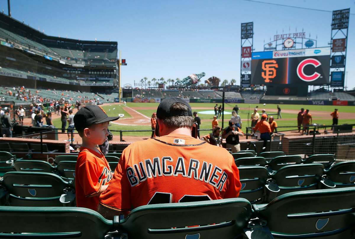 Wearing a Madison Bumgarner jersey, Adam Serrano and his son Christian, 5 1/2, settle into their seats for the Giants game against the Chicago Cubs at Oracle Park in San Francisco, Calif. on Wednesday, July 24, 2019.