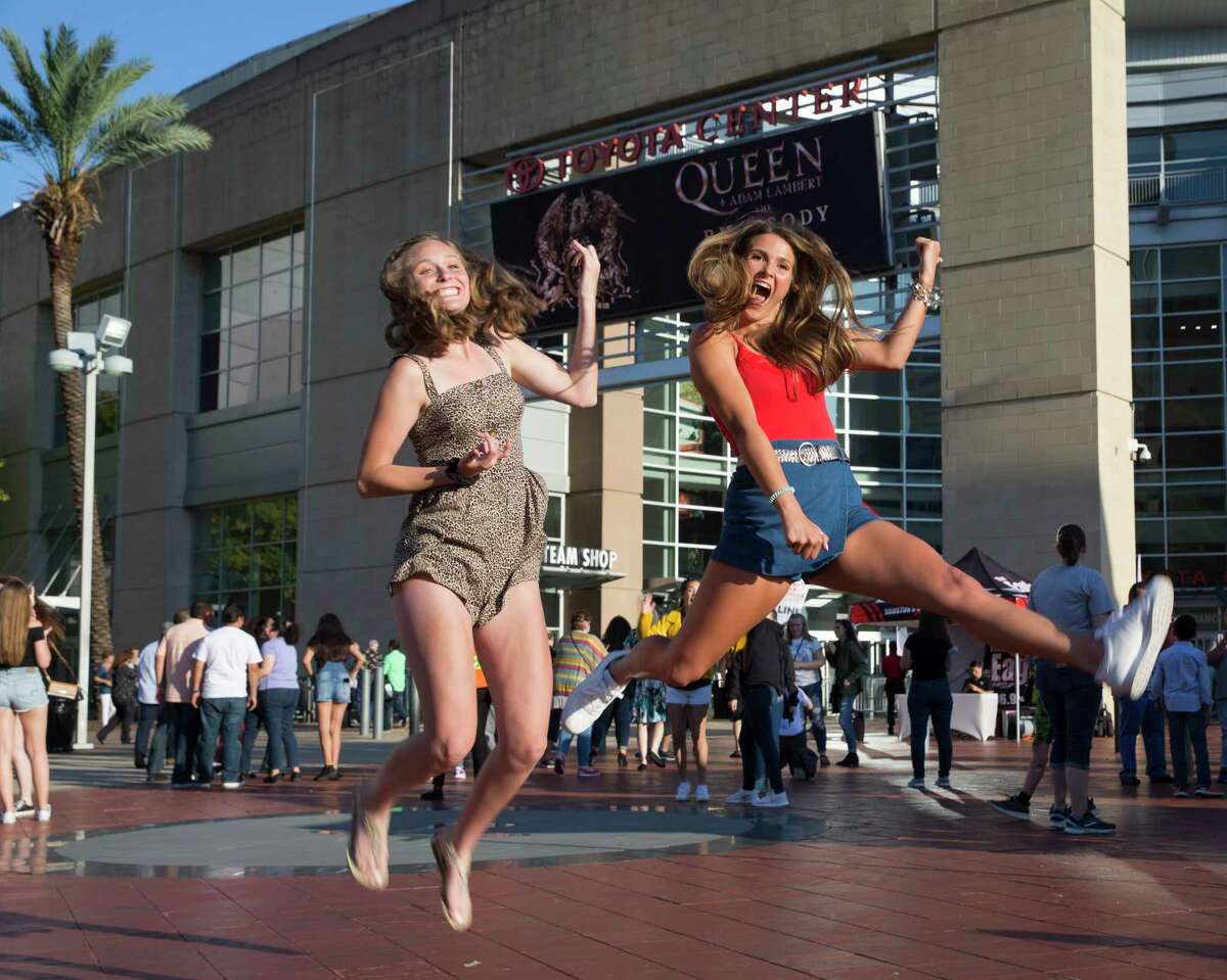 Emma Keiser, left, and Ainsley Cunningham jump in the air to take a photograph before the Queen + Adam Lambert: The Rhapsody Tour concert at Toyota Center on Wednesday, July 24, 2019, in Houston.
