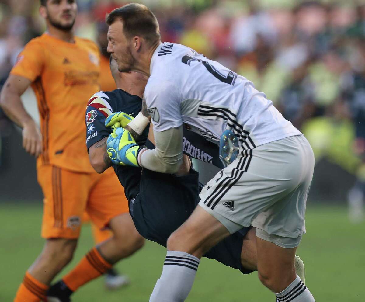 Houston Dynamo goalkeeper Joe Willis (23) has the wind knocked out of him after a collision with Club América Fernando González during the first half of a of the Leagues Cup match at BBVA Stadium on Wednesday, July 24, 2019, in Houston.
