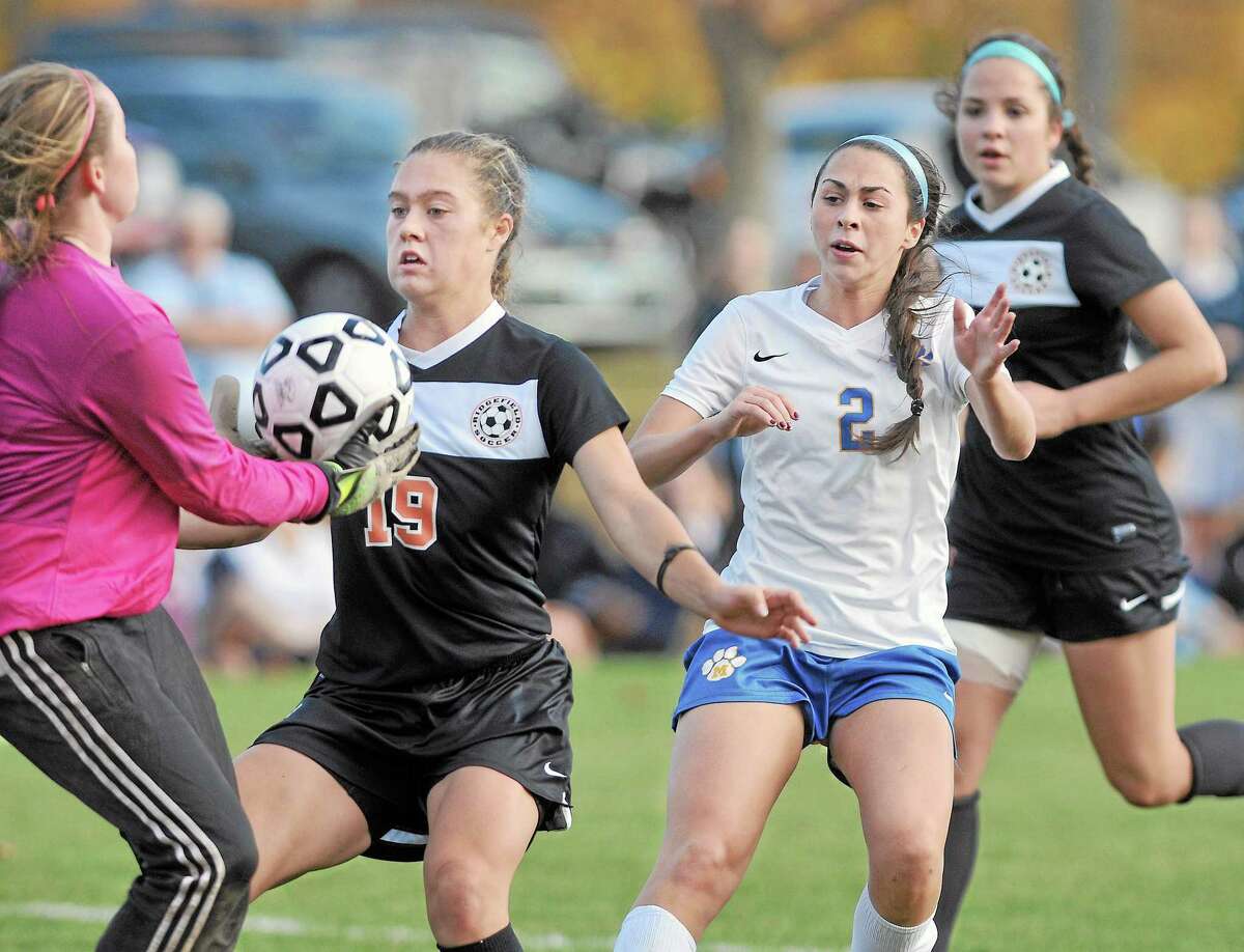 Mercy junior forward Olivia Ozycz pressures Ridgefield goalie Julia Gerber and defenders Liane Keegans (19) and Aimee Manderlink (3) during Wednesday's Second Round game of the CIAC Class LL state tournament. Ozycz scored 1 of Mercy's two goalsand went on to defeat the Ridgefield Tigers 2-1. Catherine Avalone - The Middletown Press