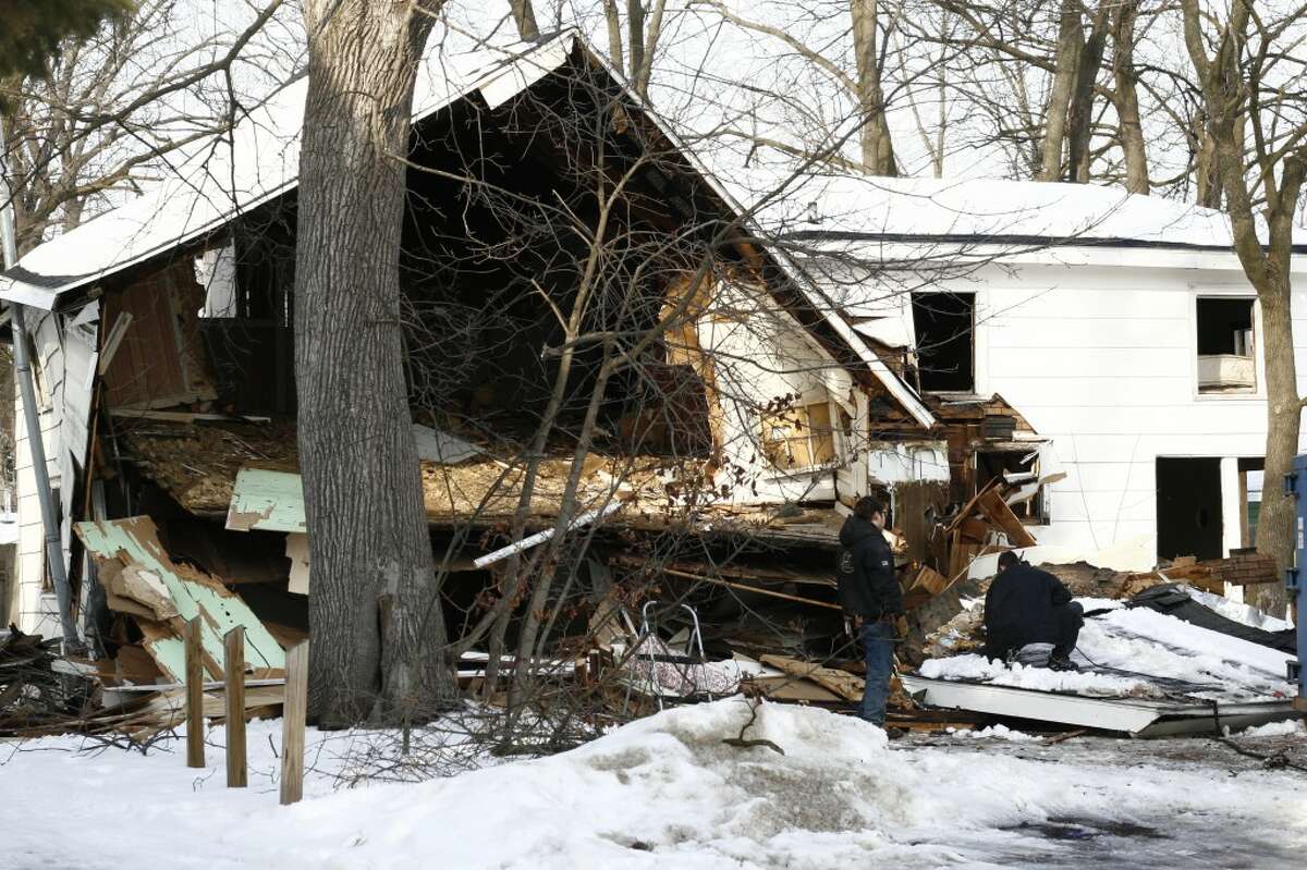 DEMOLITION: Demolition crews worked on Monday to tear down one of the houses located at 324 S. State Street in Big Rapids. The small, white house was the site of a methamphetamine investigation in 2012, but now has new owners. (Pioneer photo/Whitney Gronski-Buffa)