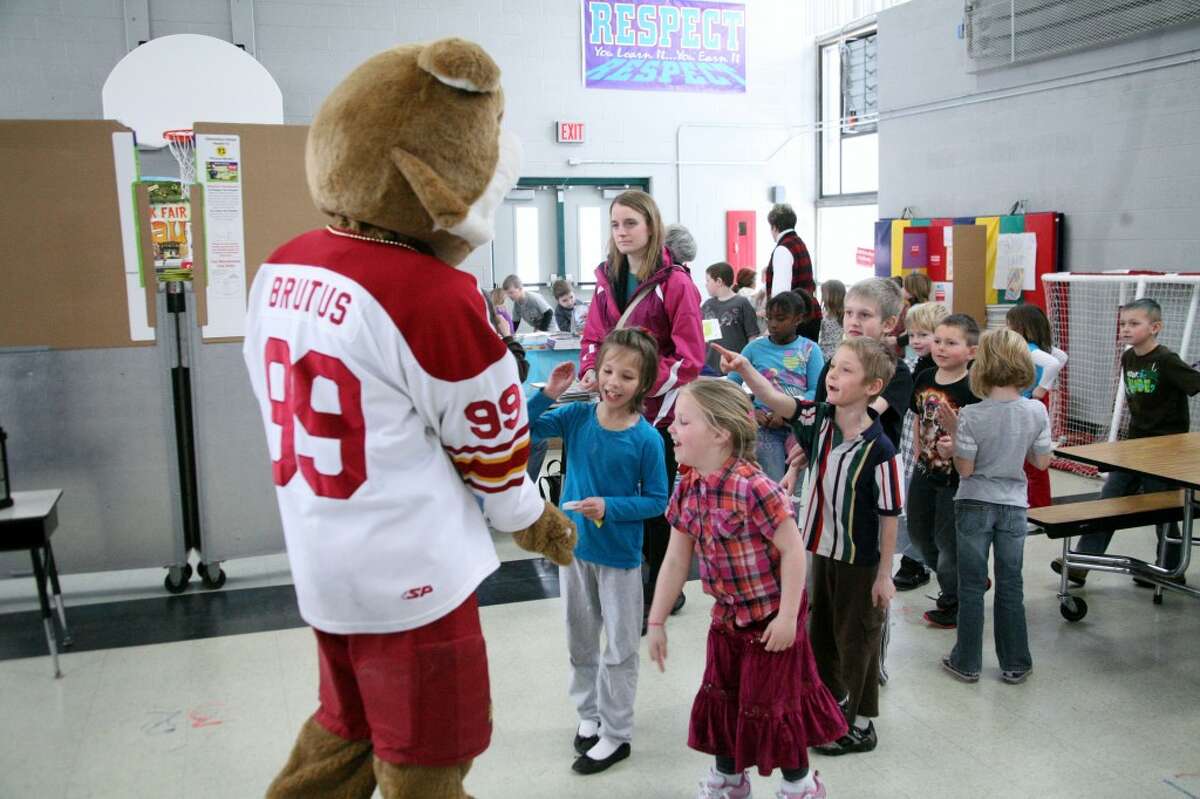 BULLDOG FEVER: Brookside students crowd around Brutus during their lunch time on Monday. The first 200 K-12 students to purchase tickets for the hockey games this weekend will receive special giveaways.