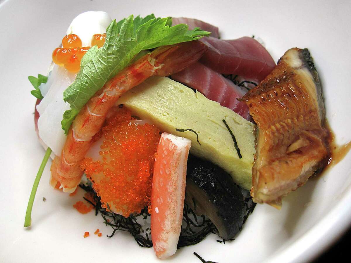 Un bol chirashi conține un sortiment de pește crud și gătit peste orez la Niki's Tokyo Inn.